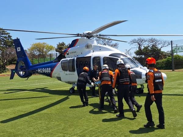 한경면 판포포구에서 익수사고를 당한 30대를 119구급대원들이 닥터헬기를 이용해 이송하고 있다. 제주도소방안전본부 제공
