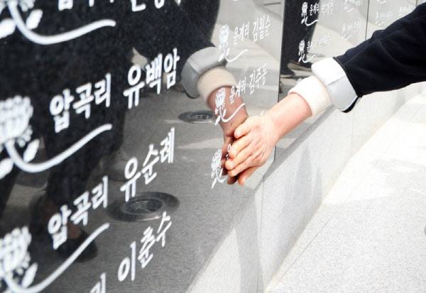 26일 오전 경남 의령군 궁류면 평촌리 의령426추모공원에서 열린 일명 ‘우순경 총기 사건’의 위령제에서 유족이 고인의 이름을 보고 눈물을 흘리고 있다. (사진=경남 의령군)