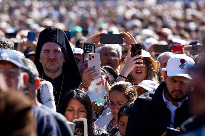 26일(현지시각) 바티칸 성 베드로 광장에서 열린 프란치스코 교황의 장례 미사에서 신자들이 휴대폰으로 장례식을 촬영하고 있다. 바티칸/로이터 연합뉴스