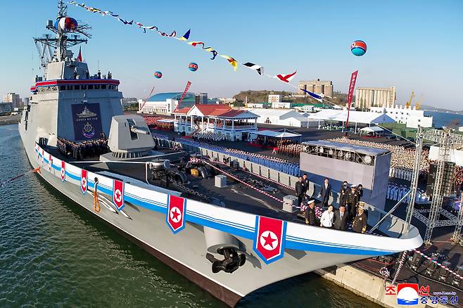 North Korean leader Kim Jong-un and his daughter Ju-ae stand at the bow of the newly launched Choe Hyon destroyer as thousands of troops and officials gather along the waterfront in Nampho Shipyard on Friday.  (Yonhap)