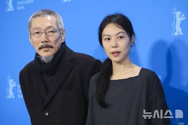 [베를린=AP/뉴시스] 홍상수 감독이 16일(현지시간) 독일 베를린에서 열린 제72회 베를린국제영화제 시상식에서 영화 '소설가의 영화'로 은곰상 심사위원대상을 받고 주연배우인 김민희와 함께 포즈를 취하고 있다. 2022.02.16.
