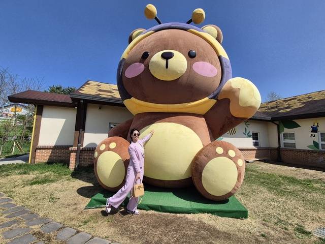 농협안성팜랜드 내 ‘꿀벌마을 허니카페’ 앞에 놓인 대형 꿀벌인형. 한 방문객이 기념촬영을 하고 있다.