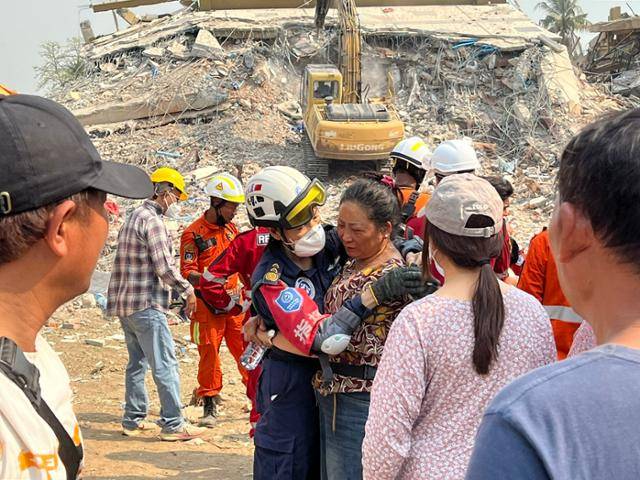 2일 지진 피해를 입은 미얀마 중북부 만달레이의 아파트 붕괴 현장에서 시신이 수습된 희생자의 유가족이 구조 대원을 껴안고 눈물을 흘리고 있다. 만달레이=허경주 특파원