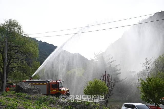 ▲ 27일 인제 상남면 하남리에서  민가에 산불이 옮겨붙지 않도록소방관계자들이 물을 뿌리고 있다. 김정호