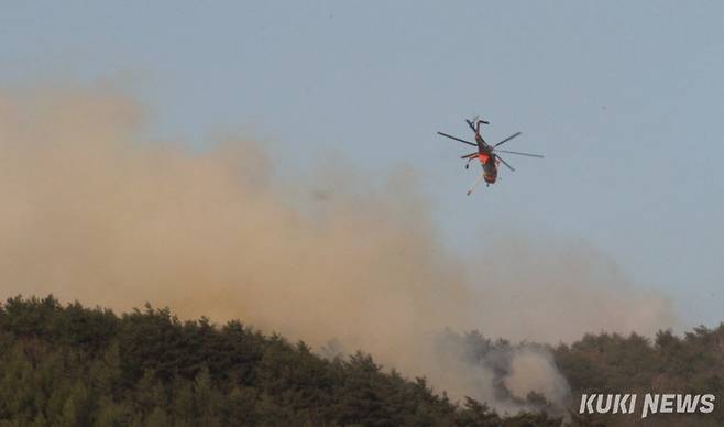 26일 강원 인제군 상남면 일대 야산에서 발생한 산불 현장에 투입된 헬기가 진화 작업을 벌이고 있다.