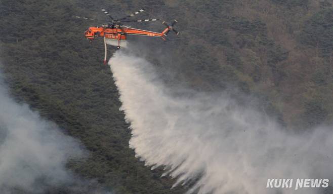 26일 강원 인제군 상남면 일대 야산에서 발생한 산불 현장에 투입된 헬기가 진화 작업을 벌이고 있다.