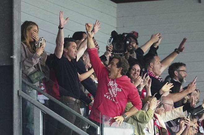 잉글랜드 프로축구 렉섬의 공동 구단주 라이언 레이놀즈(오른쪽)와 롭 매킬헤니(가운데)가 27일(한국시간) 찰턴 애틀레틱과의 경기에서 렉섬이 3대 0으로 승리를 확정한 뒤 두 팔을 들고 환호하고 있다. 연합뉴스