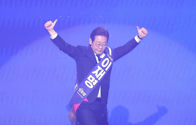 이재명 더불어민주당 대선 경선 후보가 27일 경기 고양시 킨텍스에서 열린 ‘제21대 대통령선거 후보자 선출을 위한 수도권·강원·제주 경선 및 최종 후보자 선출 대회’에서 정견 발표를 하기 위해 단상으로 이동하며 손들고 있다. [연합]