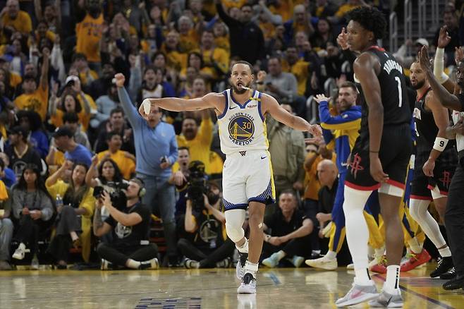 골든스테이트 스테판 커리(가운데)가 27일(한국시간) 체이스센터에서 열린 휴스턴과 NBA PO 1라운드 3차전 도중 3점슛을 터트린 뒤 환호하고 있다. 승부처에서 커리의 패스를 받은 게리 페이튼 2세의 득점이 잇따라 터진 골든스테이트가 지미 버틀러 없이 승리해 시리즈 전적 2승1패로  앞섰다. 샌프란시스코(미 캘리포니아주)｜AP뉴시스