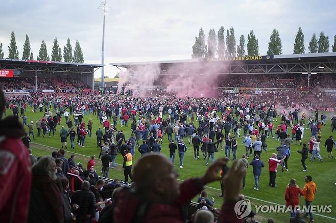 그라운드에서 승격의 기쁨을 나누는 렉섬 팬들 [AP=연합뉴스]
