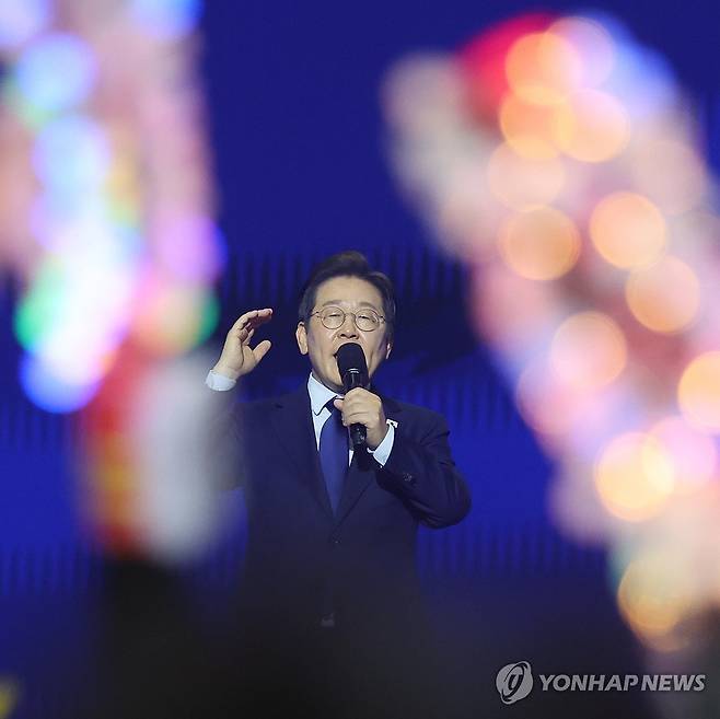 응원봉 지지 속 수락연설 하는 이재명 대선후보 (고양=연합뉴스) 김주성 기자 = 더불어민주당 대선 후보로 선출된 이재명 후보가 27일 경기 고양시 킨텍스에서 열린 '제21대 대통령선거 후보자 선출을 위한 수도권·강원·제주 경선 및 최종 후보자 선출 대회'에서 수락연설을 하고 있다. 
    지지자들이 흔드는 응원봉 사이로 연설을 하는 이재명 대선후보의 얼굴이 보이고 있다. 2025.4.27 utzza@yna.co.kr