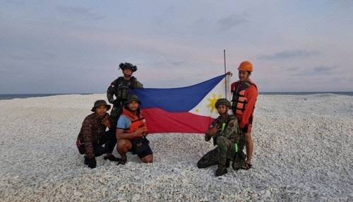 남중국해 암초서 국기 펼친 필리핀 군인들 [서필리핀해 국가 태스크포스 관계자 엑스(X·옛 트위터) 캡처]