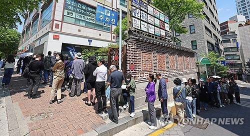 SK텔레콤이 유심 고객정보 해킹 사고로 관련 유심 무료 교체 서비스에 나선 28일 서울 시내 한 SK텔레콤 대리점 앞에 점심시간을 이용해 유심을 교체하려는 시민들이 줄지어 서 있다. [연합뉴스]