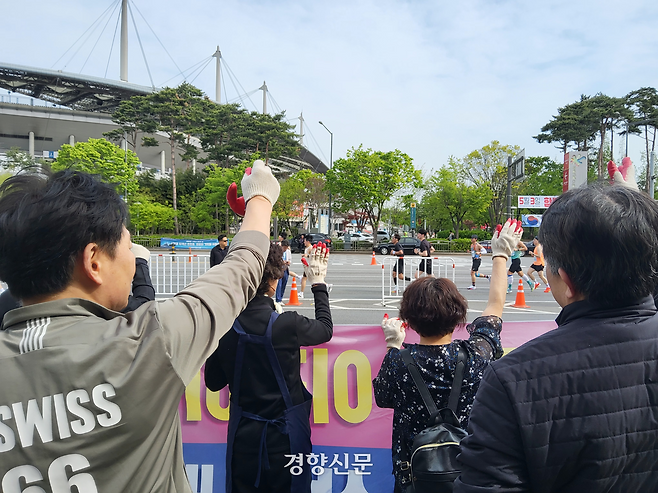 마포농수산물시장상인회가 27일 서울 마포구 마포농수산물시장 정문 앞에서 집회를 열고 마라톤 대열을 향해 도로통제에 항의하는 구호를 외치고 있다. 김태욱 기자