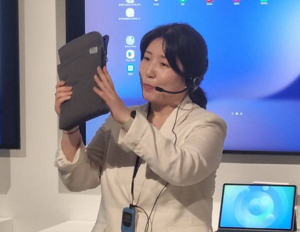 한 도슨트가 작은 파우치에 갤럭시 탭 S10 FE와 책 한 권을 넣어보였다. 정옥재 기자