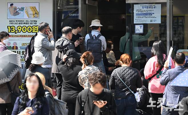 가입자 유심(USIM) 정보를 탈취당한 SK텔레콤이 유심 무료교체 서비스를 시작한 가운데 28일 오전 서울 시내 한 SKT 대리점에서 유심 교체를 하기 위한 이용자들이 줄을 서 기다리고 있다. SK텔레콤이 확보한 유심은 현재 100만 개 정도로, 가입자 2천300만 명에 비하면 턱없이 부족한 수준이다. 류영주 기자