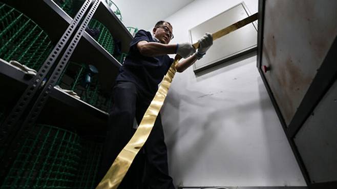 뭉툭한 금덩어리를 얇게 펴는 압연 작업