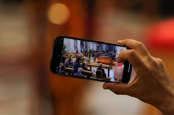 23일(현지시간) 바티칸 성 베드로 대성전에서 일반 조문객이 프란치스코 교황의 시신이 안치된 목관을 스마트폰으로 촬영하고 있다. 2025.4.23 바티칸 로이터 연합뉴스