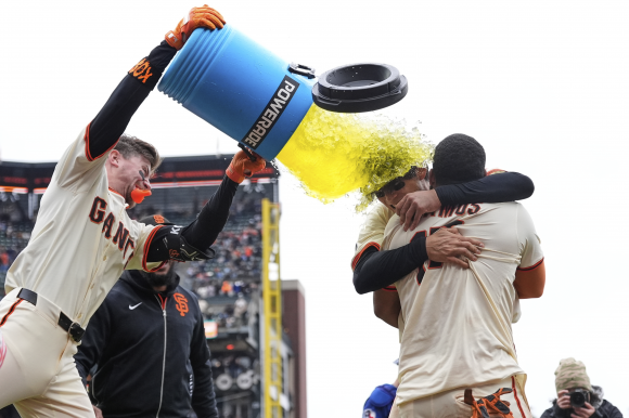 9회 말 엘리오트 라모스의 끝내기 득점 직후 이정후(가운데)를 끌어 안고 승리를 자축하고 있는 라모스(왼쪽)에게 팀 동료 크리스천 코스가 음료수를 통째 퍼붓고 있다. 샌프란시스코 AP 연합뉴스