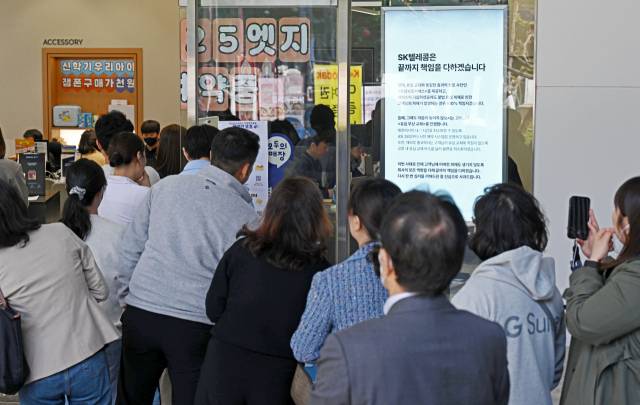 서버 해킹 사고로 가입자 유심(USIM) 정보가 탈취된 SK텔레콤이 유심 무료 교체 서비스를 시작한 28일 서울 종로구 SK텔레콤 티월드 매장 앞에 긴 줄이 이어져 있다. 조태형 기자