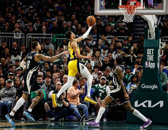 인디애나 타이리스 할리버튼(가운데)이 28일(한국시간) 파이서브 포럼에서 열린 NBA&nbsp;PO&nbsp;1라운드 4차전 도중 카일 쿠즈마(왼쪽) 등 밀워키 선수들 사이를  뚫고 레이업슛을 시도하고 있다. 인디애나가 4차전을 가져가며 시리즈전적 3승1패로 우위를 유지했다. 밀워키(미 위스콘신주)｜AP뉴시스
