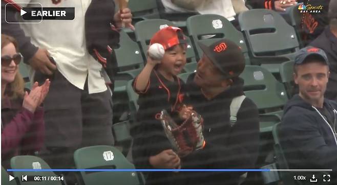 이정후가 28일 텍사스전에 앞서 관중석으로 던진 공을 받은 아버지와 아이가 공을 들고 기뻐하고 있다. 중계화면 캡처