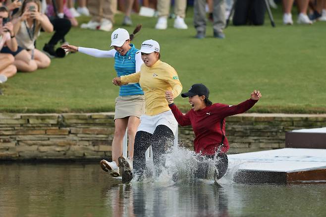 사이고 마오(가운데)가 28일(한국시간) 열린 미국여자프로골프(LPGA) 투어 메이저 대회 셰브론 챔피언십에서 일본 선수 최초로 우승한 뒤 대회 전통에 따라 18번홀 그린 옆에 있는 연못에 빠지는 ‘다이빙 세리머니’를 하고 있다. (사진=AFPBBnews)
