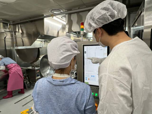 서울 영동중학교 급식실 조리사가 한국로보틱스 연구원에게 로봇 사용법을 안내받고 있다. (사진=지디넷코리아 신영빈 기자)
