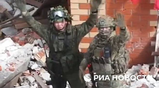 북한군(왼쪽)과 러시아군이 우크라이나 군대가 사라진 교회 건물에서 카메라를 향해 손을 흔들고 있다. /리아 노보스티