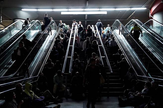 정전으로 운영이 정지된 스페인 마드리드 아토차역에서 승객들이 계단에 누워있다. /연합뉴스