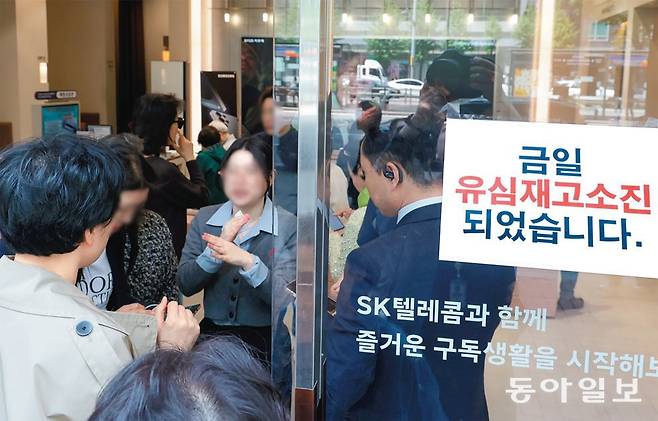 28일 오전 서울 강남구의 한 T월드 매장에서 유심 무상 교체를 받기 위해 방문한 가입자들에게 한 직원이 재고가 없다는 뜻의 ‘엑스’ 손짓을 취하고 있다. 매장 앞에도 ‘유심 재고 소진’ 안내문이 붙어 있다. 박형기 기자 oneshot@donga.com