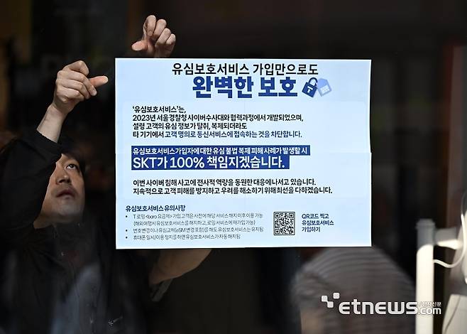SK텔레콤 PS&M 을지로점에서 관계자가 유심보호서비스 안내문을 부착하고 있다.