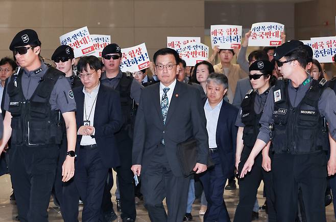 최상목 부총리 겸 기획재정부 장관이 2025년 4월22일 미국에서 열리는 ‘한미 2+2 통상 협의’와 ‘주요 20개국(G20) 재무장관 회의’에 참가하기 위해 인천공항을 통해 출국하는 가운데, 진보당 당원들이 협상 중단을 요구하며 출국에 반대하는 손팻말 시위를 하고 있다. 연합뉴스