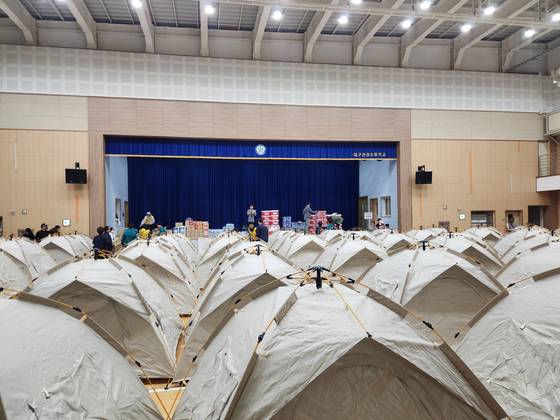 As evacuation orders are issued for more than 5,000 nearby residents due to a wildfire on Mount Hamji in Buk District, Daegu, tents are set up for evacuees at the gymnasium of Yeongyeong Elementary School in the early hours of April 29. [YONHAP]