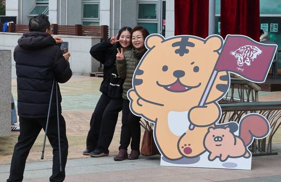 A student takes a photo with her family at Korea University's matriculation ceremony on Feb. 29, 2024. [YONHAP]