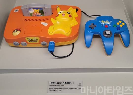 넷마블게임박물관. 닌텐도의 '닌텐도 64: 피카츄 에디션'. 1996년 출시된 기기이다. 닌텐도 64는 슈퍼 패미콤의 후속 기기로, 세가 새턴, 플레이스테이션과 경쟁했던 게임기다. 그러나 이 게임기는 당시 최고의 인기였던 플레이스테이션은 물론, 세가 새턴에도 판매량이 밀리는 굴욕을 맛봤다. 당시 대용량의 데이터를 담을 수 있어 업계 표준화 되고 있던 CD-ROM을 사용하지 않았을 뿐 아니라(CD-ROM 용량은 600메가가 넘는데, 닌텐도 64의 카트리지 최대 용량은 64MB에 불과했다. 원가도 CD-ROM이 훨씬 저렴했고, 유통도 원활했), 게임 제작 난이도가 높아 닌텐도 자체 게임 외에 게임이 적었고, 이에 따라 당시 많은 서드파티들이 플레이스테이션으로 빠져나갔다는 점은 닌텐도에게 있어 많은 반성을 하고 정책을 바꾸는 계기가 됐다. 촬영 : 이동근 기자
