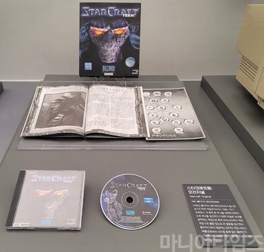 넷마블게임박물관. 1998년 발매된 블리자드의 PC용 RTS게임 '스타크래프트'. 사진은 잔인한 장면을 삭제한 전연령용 TEEN 버전이다. 한국 한정으로 현 시대까지 인기를 끌고 있는 게임이다. 한국의 PC방 문화를 이끌었고, 프로게이머라는 직종을 탄생시키며 e-스포츠라는 분야를 만들었고, '한국의 명절 민속놀이'라는 평가까지 받고 있다. 또, 인터넷을 통해서 즐기는 '대전 멀티플레이' 게임 중 최고의 인기를 끌면서 한국내에서만 450만 장 이상의 판매량을 기록하며 PC게임을 정품으로 구입해야 한다는 문화도 어느 정도 이끌었다. 한국에서 인기를 끈 이유는 운보다는 실력이 좌우하는 게임의 승패, 빠른 속도, 적절한 1판 당 플레이 시간, 완벽에 가까운 종족별 밸런스, 당시 수준으로 높은 수준인 그래픽, 높은 수준의 최적화(2017년 1.18 패치 이전) 등이 꼽힌다. 게임 자체는 난이도가 꽤 높은 편이었는데, 단축키를 이용한 플레이가 강제되고, 두뇌 플레이 보다는 아케이드 게임에 가까운 빠른 손놀림이 강제됐기 때문이다. 오래된 게임이다 보니 전략도 엄청나게 연구돼 늦게 유입된 젊은 층은 게임에 진입하기 어렵다는 평가도 있다. 여담으로 블리자드에서도 한국의 게이머 수준을 높게 평가해 멀티 서버 중 한국의 서버를 별도로 주고, '고요한 새벽의 나라는 전쟁 기술을 통달했으며, 지구에서 가장 유명한 스타크래프트 플레이어들의 고향이 되었습니다. 이 무시무시한 전쟁터에 생각 없이 발을 들이지 마십시오'라는 안내 문구를 적어두었다. 다만 한국 외에서는 명작으로 꼽히긴 하지만 한국만큼 인기를 끌지는 못했다. 한국인 국민성과 궁합이 아주 좋았던 케이스. 원래 블리자드는 일본을 주 타깃 층으로 삼아 게임을 제작했는데, 정작 일본에서는 히트치지 못했다. 일본을 타깃으로 한 흔적은 배틀크루저의 '야마토포' 명칭 등에 남아 있다. 한국에서 엄청난 인기를 끌었지만 한글 지원은 사실 장기간 이어지지 않았고, 2005년에 들어서야 게임 클라이언트와 배틀넷에서 한글을 지원했고, 2017년 8월에서야 한글 현지화를 공식 지원했다. 촬영 : 이동근 기자