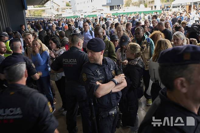 [바르셀로나=AP/뉴시스] 28일(현지 시간) 스페인에서 대규모 정전 사태가 발생한 가운데 경찰이 폐쇄된 바르셀로나 기차역 정문을 통제하고 있다. 이날 스페인과 포르투갈에서 발생한 대규모 정전으로 기차, 지하철, 항공기 등 주요 교통수단이 마비되며 피해가 잇따랐다.  2025.04.29.