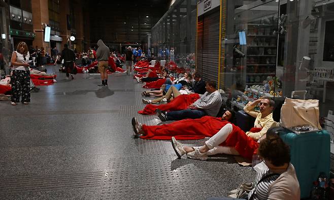 스페인과 포르투갈 등 이베리아반도 전역과 프랑스 남부 등에 대규모 정전이 발생해 주요 인프라가 마비된 가운데 28일(현지시간) 스페인 코르도바의 기차역에 발이 묶인 여행객들이 담요를 덮고 역 바닥에 누워 있다. 코르도바=AFP연합뉴스