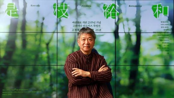 한국을 찾은 고레에다 히로카즈 감독이 씨네큐브 ‘개관 25주년 기념 고레에다 히로카즈 특별전’을 배경으로 포즈를 취하고 있다. 씨네큐브 제공