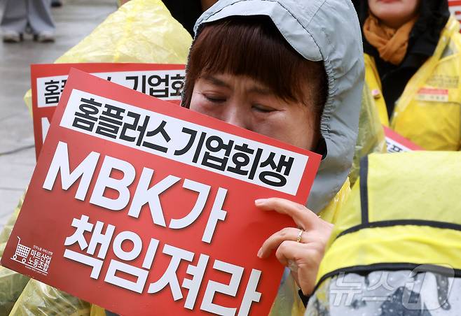 민주노총 서비스연맹 마트산업노조 지부 회원들이  지난 14일 서울 종로구 MBK파트너스 앞에서 열린 'MBK가 책임져라 확대간부 결의대회'에서 삭발하는 안수용 지부장을 지켜보며 눈물을 흘리고 있다. 2025.4.14/뉴스1 ⓒ News1 김진환 기자