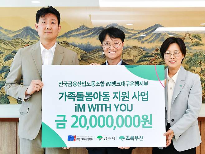 (왼쪽부터)백지노 전국금융산업노동조합 iM뱅크대구은행지부 위원장과 이재훈 영주시장 권한대행 , 박정숙 초록우산어린이재단 경북지역본부장이 지난 29일 영주시청에서 진행된  'iM WITH YOU 가족돌봄 행사'에서 기념촬영을 하고 있다.