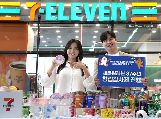 모델들이 세븐일레븐 37주년 기념 홍보물을 들고 홍보하고 있다. 코리아세븐 제공