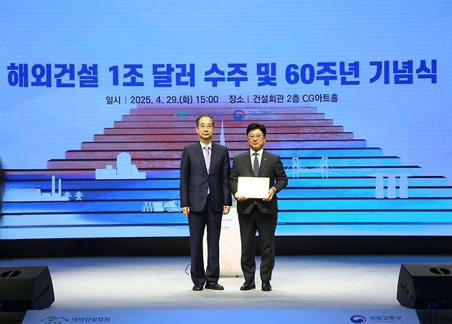 동아건설산업 임동복 대표이사(오른쪽)가 지난 29일 서울 강남구 건설회관에서 열린 '해외건설 1조 달러 수주 및 60주년 기념식'에서 한덕수 대통령 권한대행 국무총리(왼쪽)에게 '대한민국을 빛낸 해외건설 10대 프로젝트' 선정 기념패를 수여 받고 기념촬영을 하고 있다. SM그룹 제공