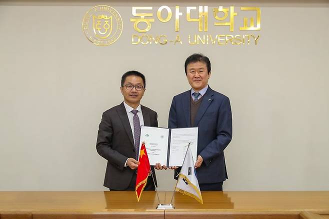 강대성 동아대 부총장(오른쪽)과 웨이지엔쥔 상하이체육대학 부총장이 지난 28일 협약서를 들고 포즈를 취하고 있다. 동아대 제공