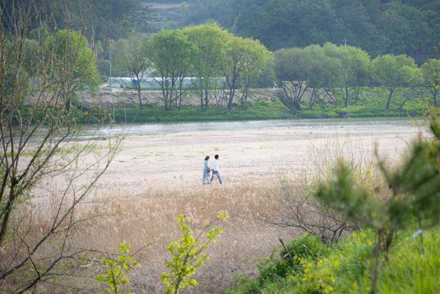 손을 잡은 두 사람이 경북 영주시 무섬마을 인근 모래사장을 걷고 있다.
