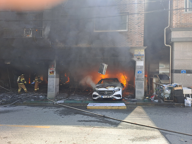 29일 전북 전주시 완산구의 한 빌라 건물 주차장에 있던 차량에서 불이 나 소방대원들이 불을 끄고 있다. 전북도소방본부 제공