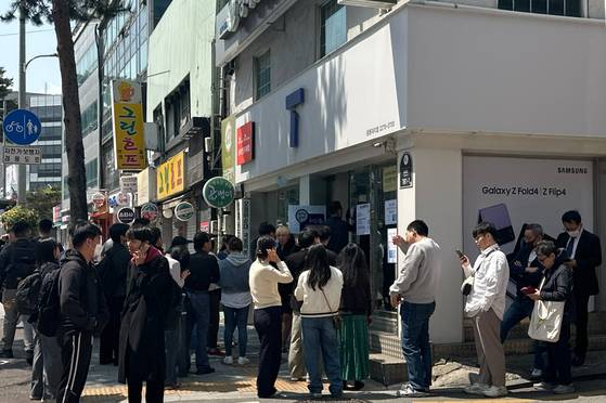 Customers wait outside an SK Telecom branch in central Seoul on April 28 [CHO YONG-JUN]