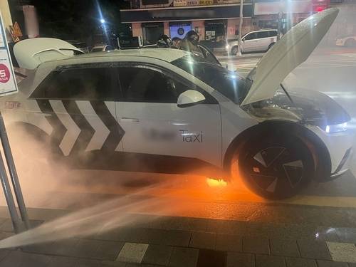 30일 오전 부산에서 운행중이던 전기차 택시에 불이 나 진화하고 있다. [부산소방재난본부]