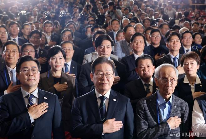 [서울=뉴시스] 조성우 기자 = 이재명(앞줄 가운데) 더불어민주당 대선후보가 30일 오후 서울 여의도 국회 의원회관에서 열린 더불어민주당 제21대 대통령선거 '진짜 대한민국' 중앙선거대책위원회 출범식에서 국기에 대한 경례를 하고 있다. 2025.04.30. xconfind@newsis.com /사진=조성우